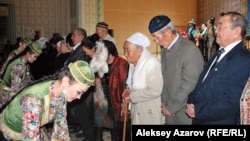 Kazakhstan – Kazakh Girls hand presents to elders, former classmates of Nazarbaev. Almaty, 20Dec2013